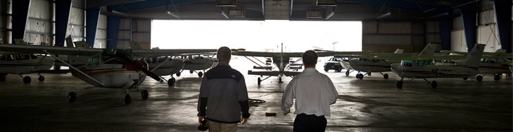 Men viewing planes inside a hangar